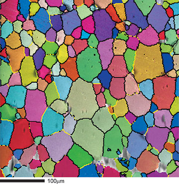 図4．SrTiO3のOIM方位マップと二次電子像の重ね合わせ像。特別な境界を黄色でハイライト表示